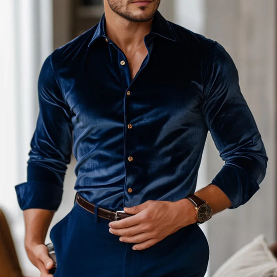 Man wearing a dark blue velvet shirt with a blurred background